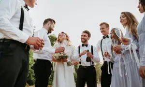 Para ślubna z szampanem i świadkami w eleganckich strojach.