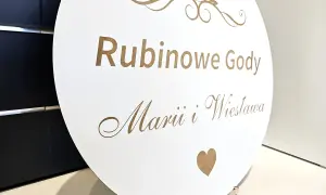 Okrągła biała tablica z napisem "Rubinowe Gody" i imionami, ozdobiona cyfrą 40 i sercem.
