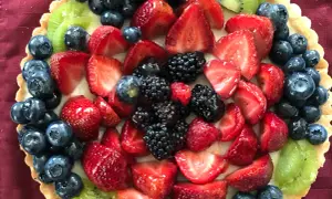 Kolorowa tarta z owocami: truskawki, borówki, jeżyny i kiwi.