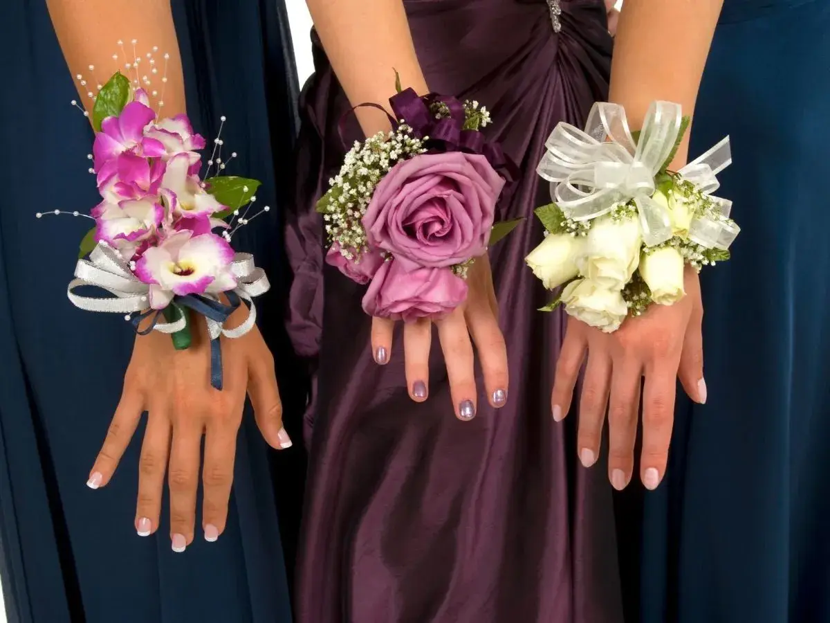 Trzy eleganckie korsarze dla świadkowej: różowe orchidee, fioletowa róża i bukiecik białych róż, ozdobione wstążkami i zielenią.