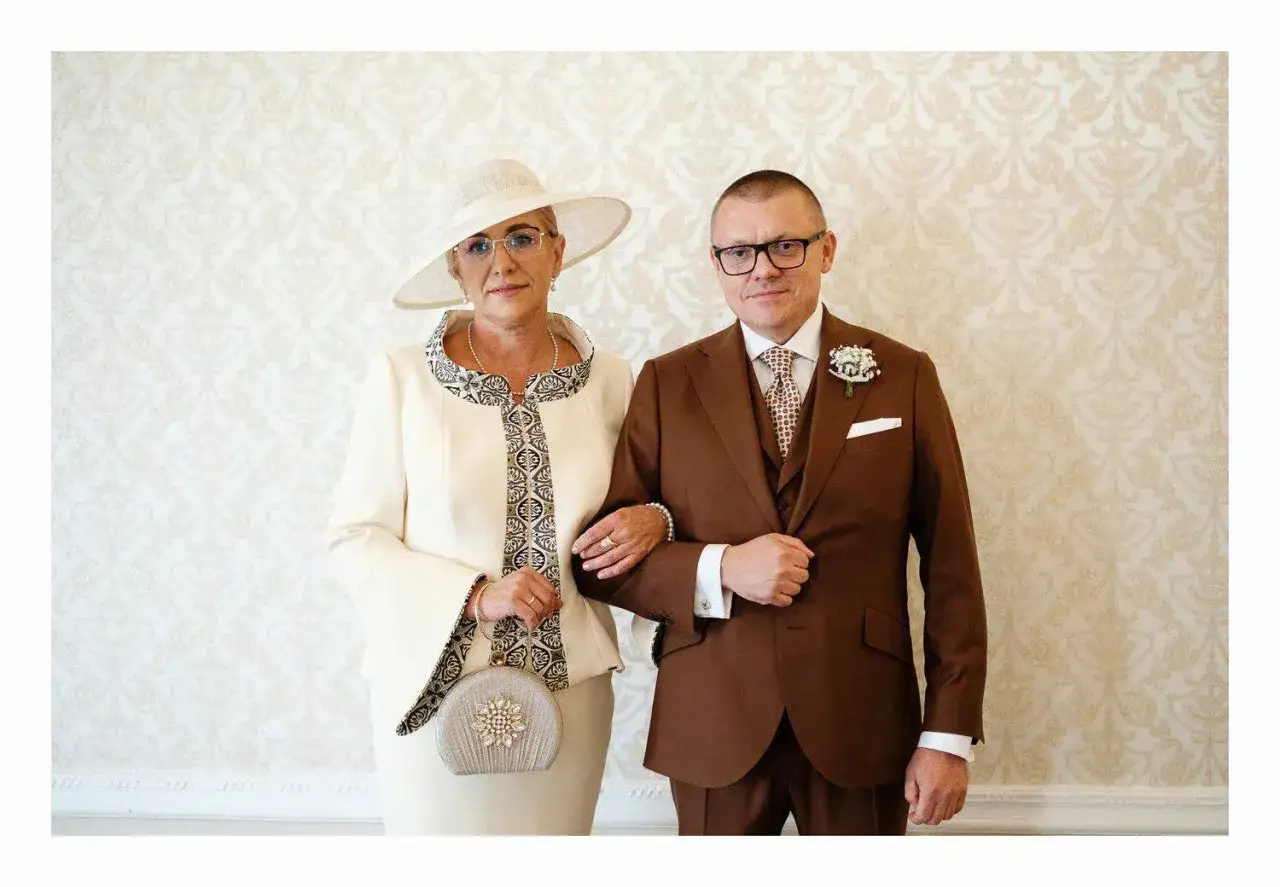 Elegancka mama pana młodego w kremowym kostiumie i kapeluszu, idealna inspiracja, jak powinna się ubrać mama pana młodego na ślub.