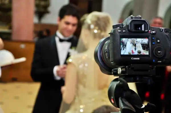 Aparat fotograficzny nagrywa ślub parę młodą w kościele.
