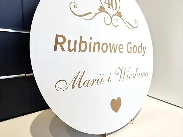 Okrągła biała tablica z napisem "Rubinowe Gody" i imionami, ozdobiona cyfrą 40 i sercem.